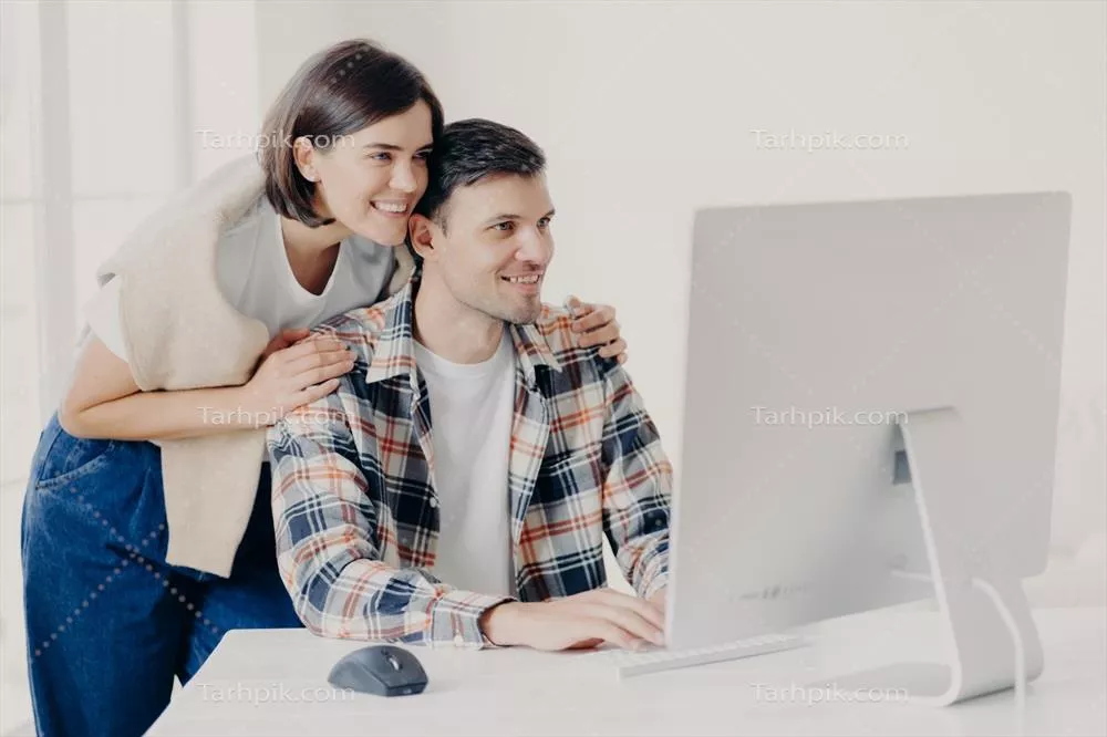 عکس زوج جوان با همکاری یکدیگر در حال توسعه یک پروژه اینترنتی