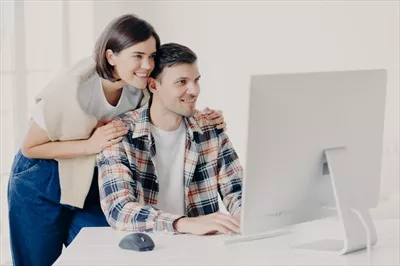 عکس زوج جوان با همکاری یکدیگر در حال توسعه یک پروژه اینترنتی