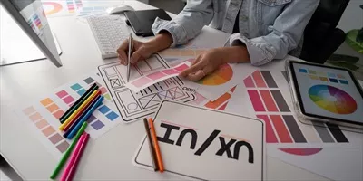 عکس زنی شیک و خلاق در حال طراحی وب سایت با تبلت و کامپیوتر در دفتر کار خانگی