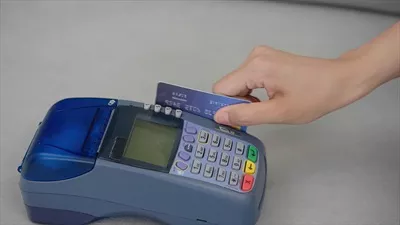 عکس تصویری نزدیک از دست در حال کشیدن کارت اعتباری برای خرید
