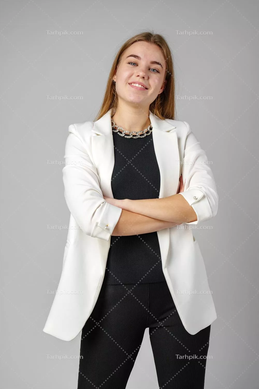 عکس زنی با بلوز مشکی و ژاکت سفید در استودیو در حال مدلینگ