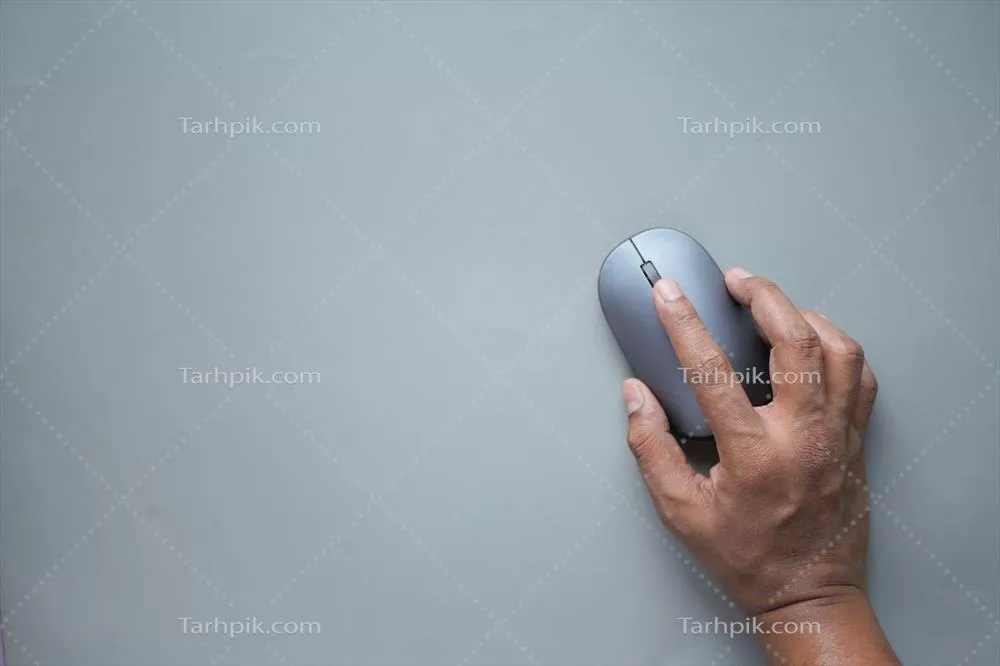 تصویر از بالا از دست یک شخص که در حال استفاده از ماوس بر روی پس زمینه خاکستری است