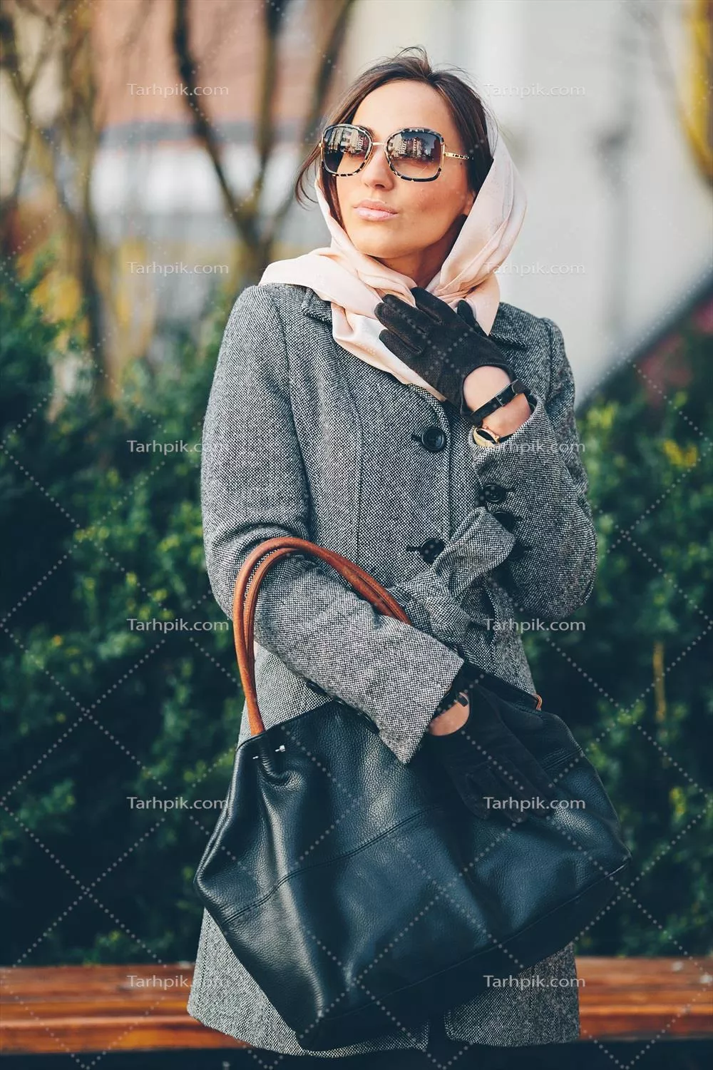 دختری خوشحال، جوان و زیبا که در پارک به حالت نمایش ایستاده است