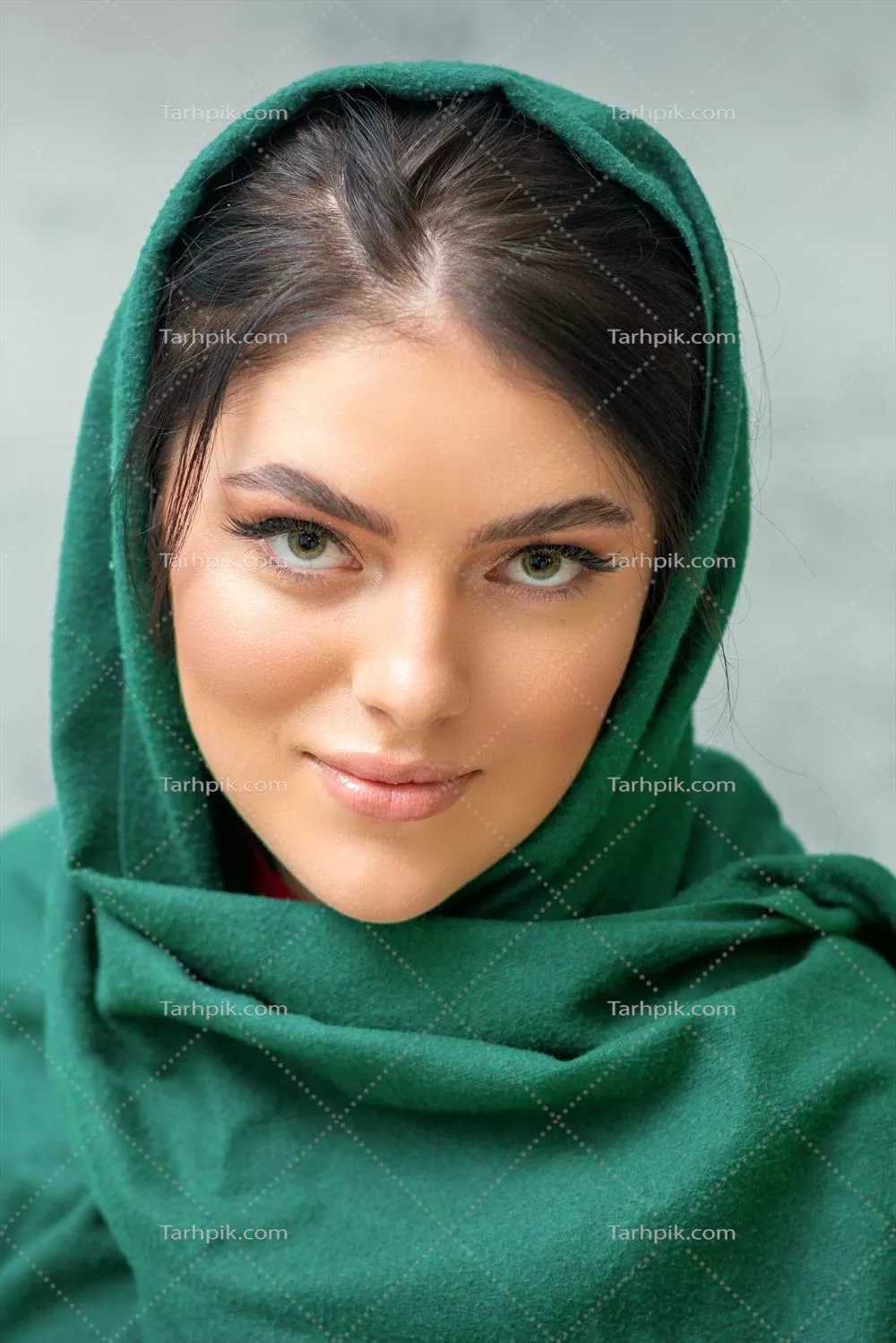 پرتره ای از یک زن جوان و زیبا با آرایش و روسری سبز در پس زمینه خاکستری