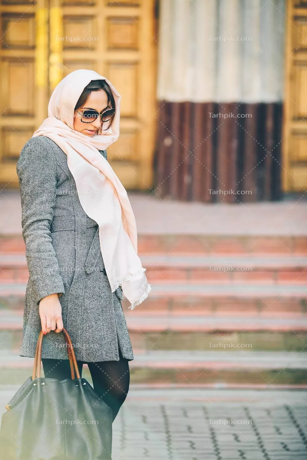 دختر در کت با پسزمینهای از ساختمان در حال posing