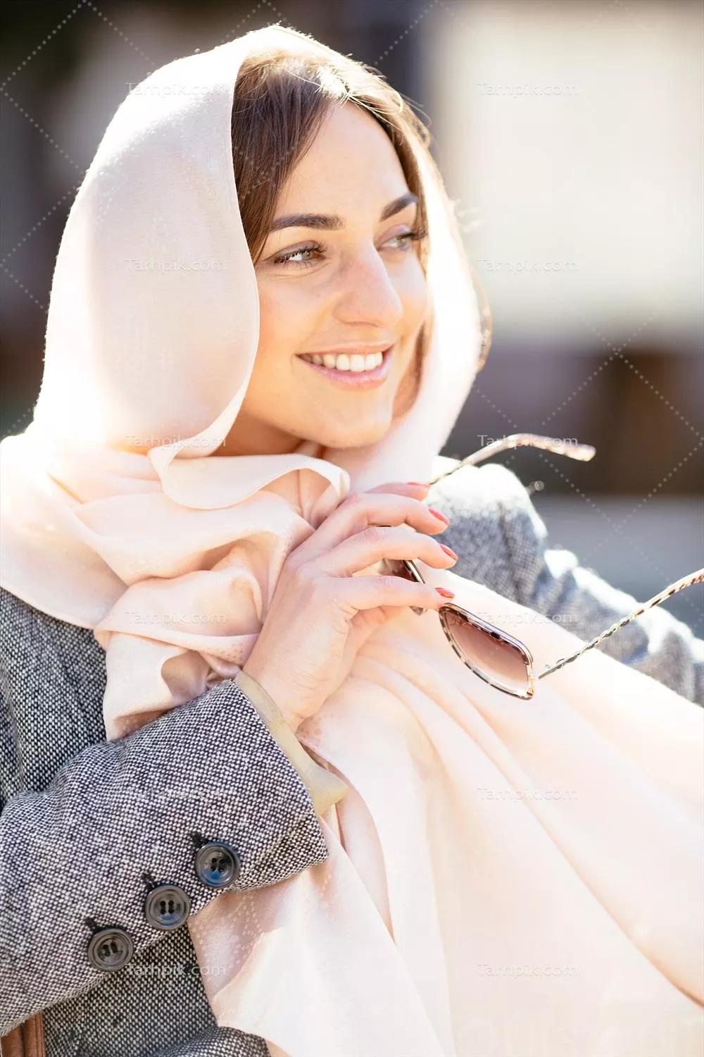 دختری در حال حرکت با پالتویی شیک در خیابان های شهر