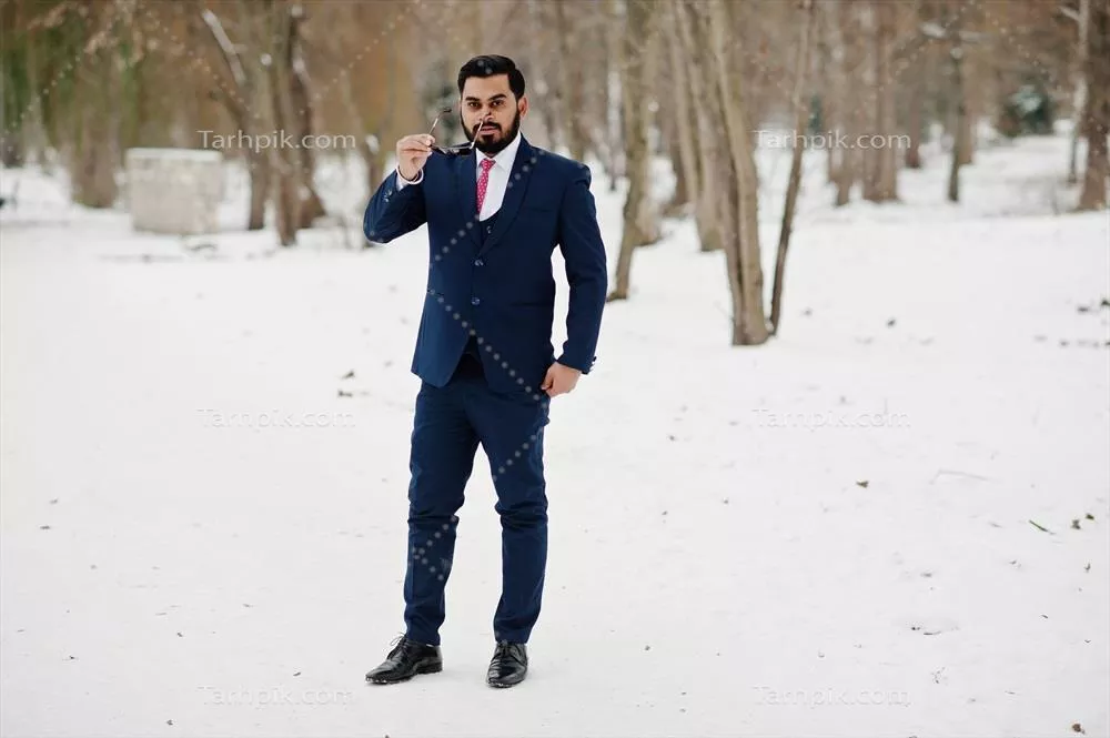 مرد کسب و کار با ریش شیک و کت و عینک آفتابی در زمستان