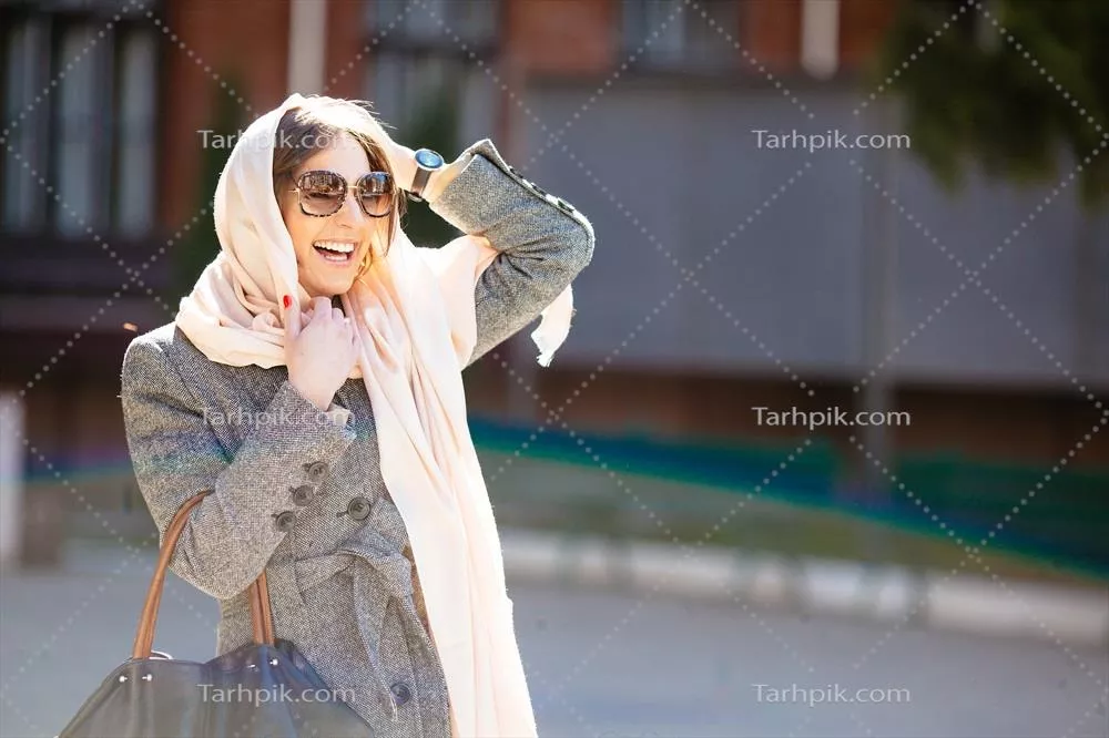 دختری در خیابان با کتی شیک و مدرن در حال پیاده روی