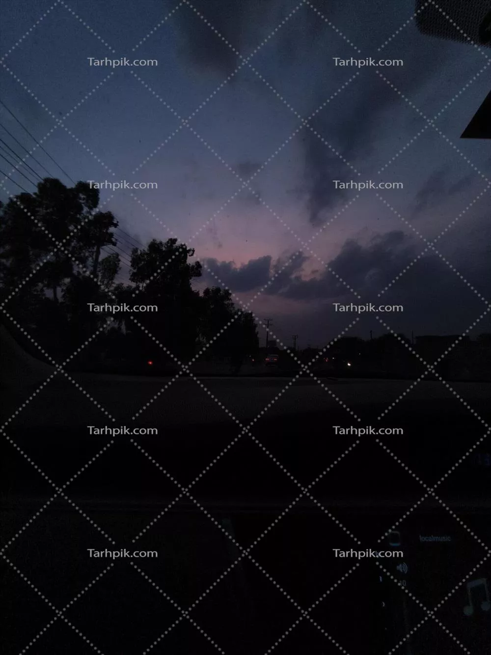 منظره آسمان گرگ و میش از پنجره خودرو با سیلوئت درختان و ابرها برای سفر و عکاسی طبیعت