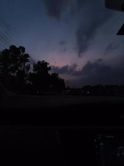منظره آسمان گرگ و میش از پنجره خودرو با سیلوئت درختان و ابرها برای سفر و عکاسی طبیعت