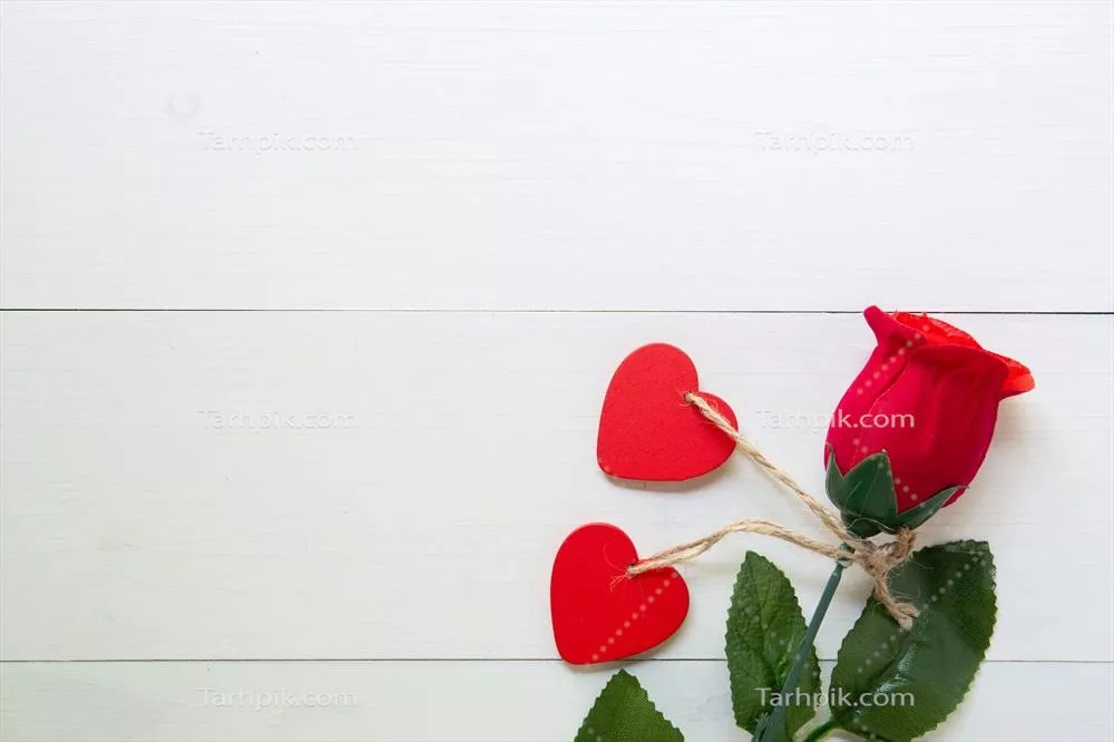 هدیه ای ویژه با گل رز قرمز و شکل قلب بر روی میز چوبی در روز ولنتاین