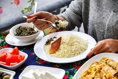 شخصی که از یک بشقاب بر روی میز غذا لذت میبرد