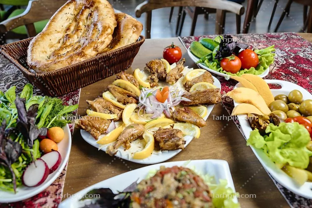 میز با ظرف های غذا و سبد نان، نماد مهمان نوازی و جشن های دوستانه