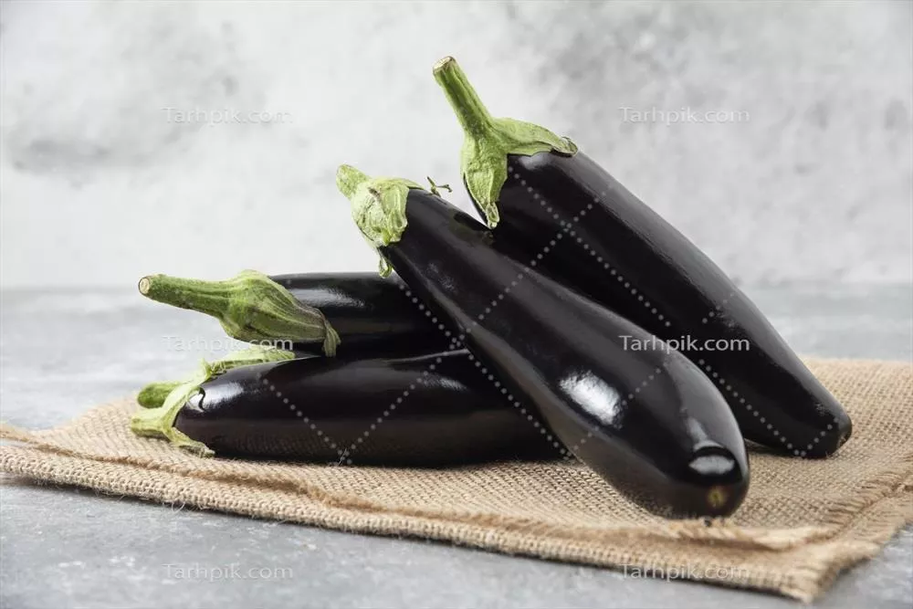 بادمجانهای تازه و خام قرار گرفته بر روی پارچهای از گونی
