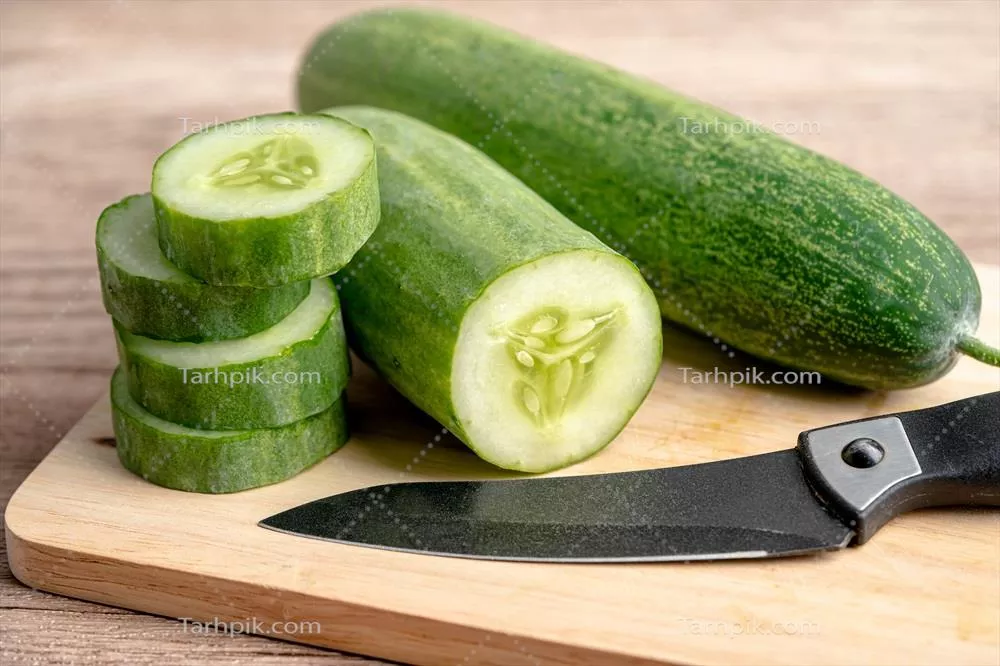 خیار تازه و سالم برش خورده با چاقو بر روی تخته برش برای آشپزی در آشپزخانه