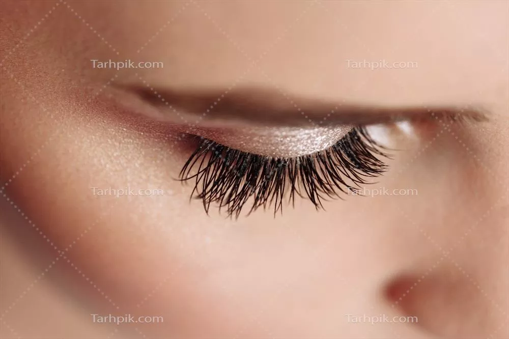 تصویری نزدیک از یک زن زیبا با مژههای بلند سیاه و ابروهای چشمنواز در حالت زیبایی