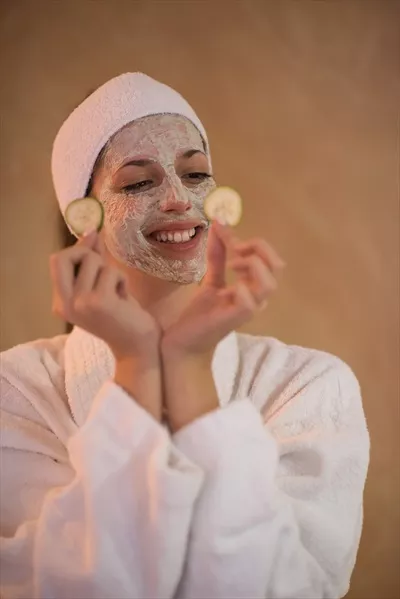زن در اسپا در حال استفاده از ماسک صورت برای زیبایی و آرامش