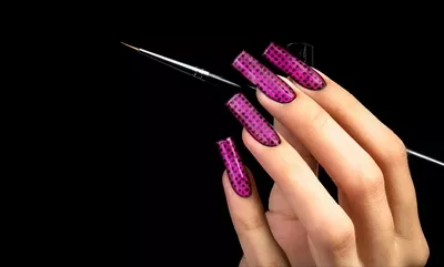 طراحی ناخن با لاک زیبا و هنرمندانه بر روی پس‌زمینه سیاه