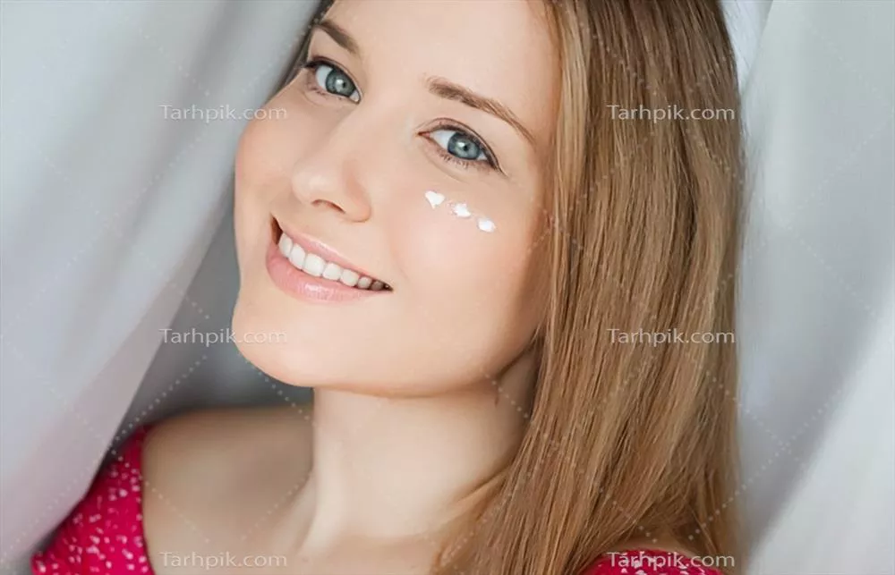 زنی زیبا با کرم مراقبت از پوست بر روی صورتش