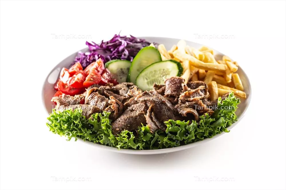 کباب گوسفند ترکی خوشمزه و سِرو شده در بشقاب سفید با سالاد تازه و سیب‌زمینی سرخ‌کرده