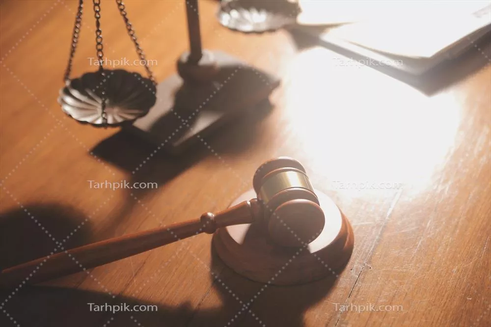 تصویر وکیلان در حال بحث در مورد قراردادها با ترازوی برنجی در دفتر حقوقی