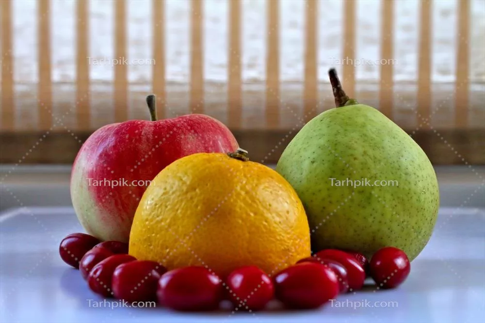 مجموعه میوههای تازه شامل میوههای کامل و توتهای گزنه بر روی سینی سفید