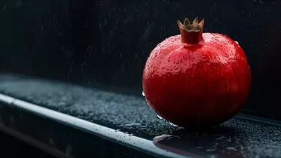 رمانتیکترین دانههای انار قرمزرنگ بر روی سطح مشکی