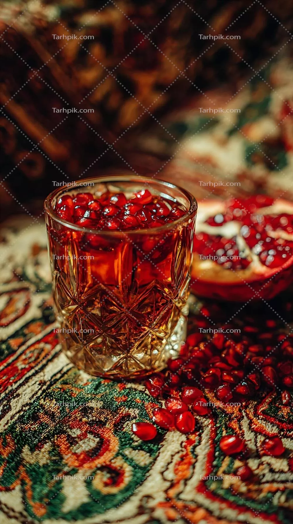 نوشیدنی تازه انار با دانه های پراکنده بر روی فرش رنگارنگ