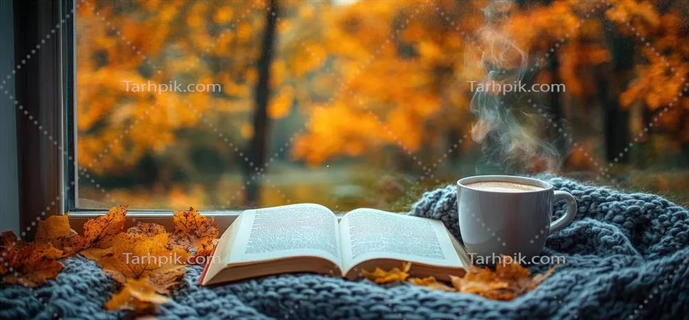 صحنه ای دنج از پاییز با فنجان قهوه بخ بخار و کتاب در کنار برگ های پاییزی