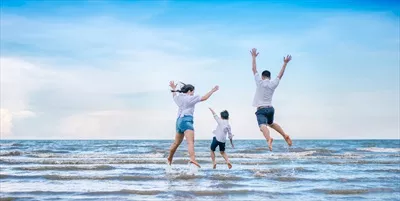 خانواده ای شاد که در سواحل در حال پرش و شادی هستند