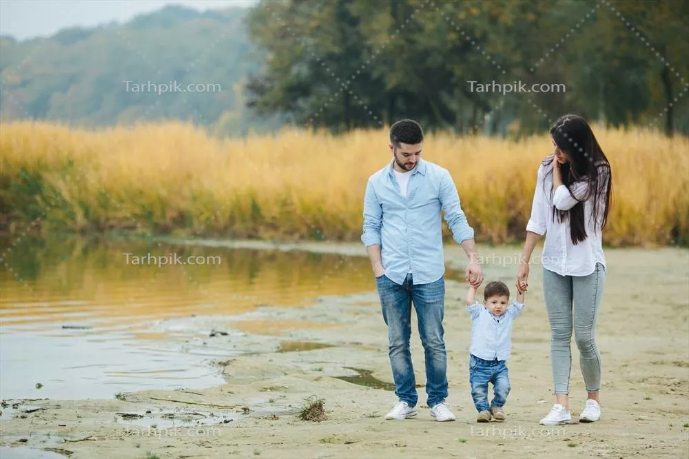 خانواده جوان در حال پیاده‌روی در ساحل: لحظات شاد و آرامش‌بخش