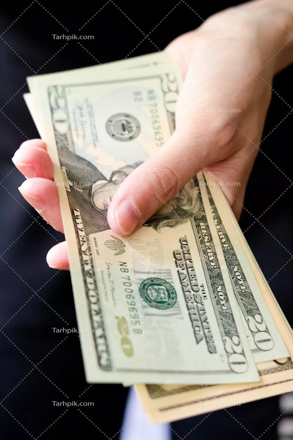 تصویر نزدیک از یک دسته دلار در دست‌ها برای شمارش مبلغ نقدی روز پرداخت