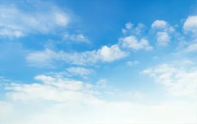 مناظر طبیعی با آسمان آبی، ابرهای سفید و تابش نور خورشید