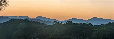 غروب خورشید در کوهها با رودخانه و درخت نخل زیبا