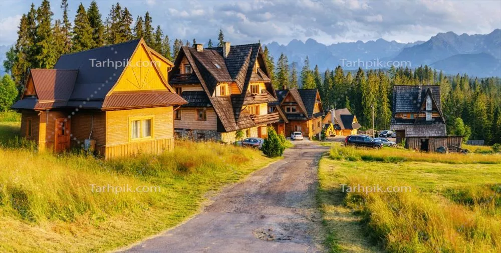 خانه چوبی سنتی در کوهستان با چشم اندازی به دشت های سبز در لهستان