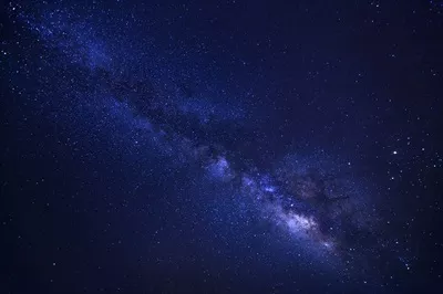آسمان پرستاره و کهکشان راه شیری با ستاره‌ها و غبار فضایی در جهان