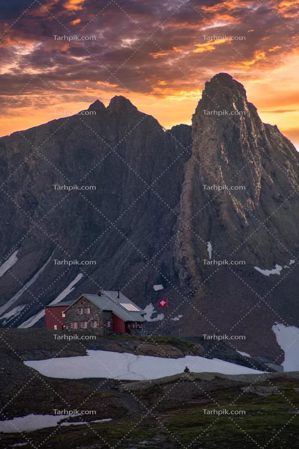 اقامتگاه کوهستانی سوئیسی در قله کوه با غروب آفتاب دراماتیک