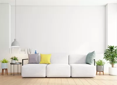 طراحی مینیمالیستی سالن نشیمن با مبل و میز جانبی بر روی دیوار سفید و کف چوبی