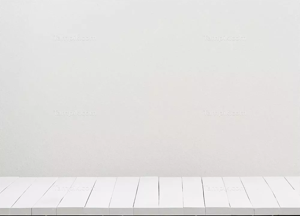 میز چوبی سفید رنگ در کنار دیواری سفید و ساده