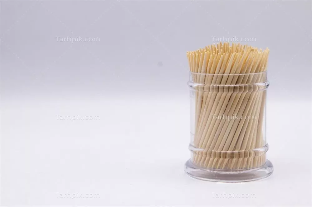 چوب دندان‌پزشکی در نگهدارنده شفاف شیشه‌ای بر روی پس‌زمینه سفید