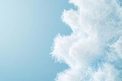 الیاف نرم و سفید ایجاد بافتی ظریف در برابر پس‌زمینه آبی روشن