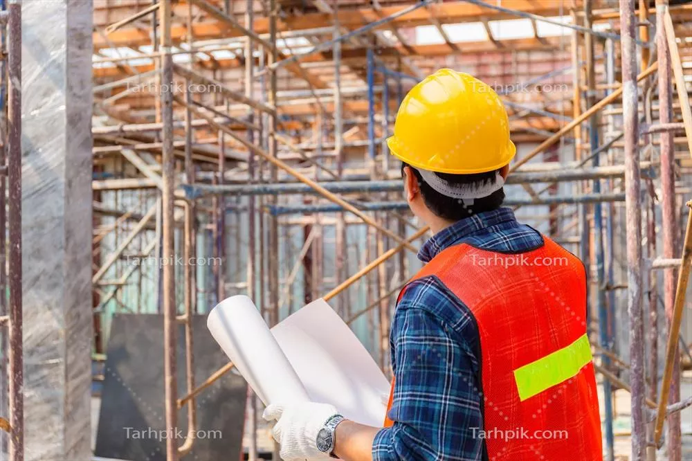 مهندس در حال بررسی و برنامه‌ریزی پروژه در محل ساخت‌وساز با نقشه در دست