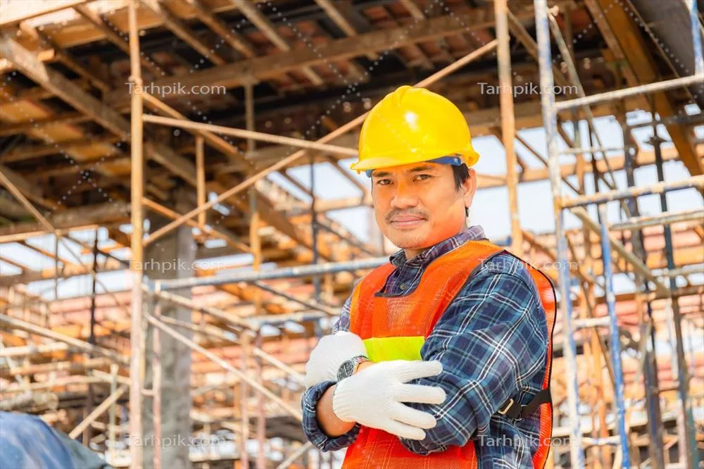 مهندس مرد در حال بررسی و برنامه‌ریزی پروژه در محل ساخت‌وساز با لبخند