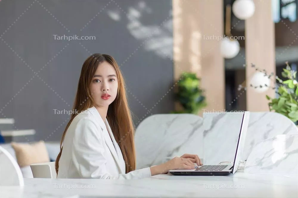 زنی آسیایی و حرفهای در حال کار جدی با لپتاپ در دفتر کار