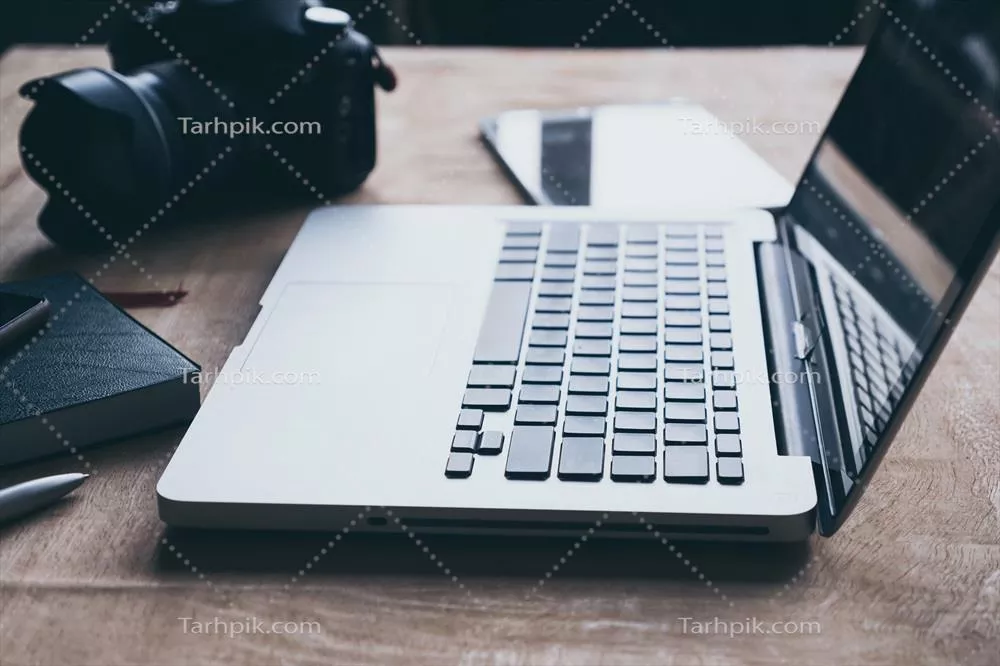 لپتاپ، تبلت و دوربین بر روی میز چوبی - یک ترکیب مدرن برای کار و تفریح