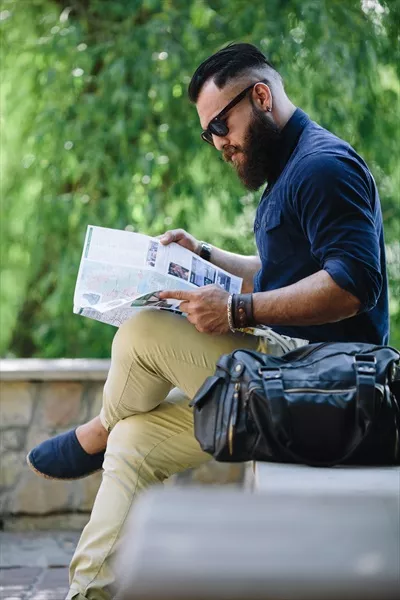 مردی با ریش که به نقشه نگاه میکند و در جستجوی مسیرهای جدید است