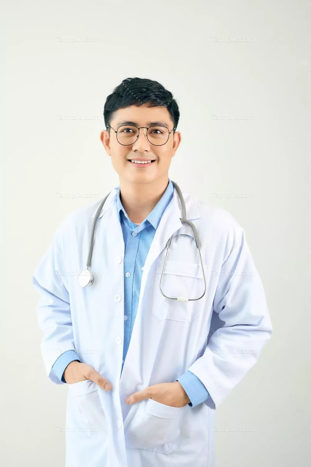 یک پزشک خوشتیپ با گوشی پزشکی که با اعتماد به نفس روی پسزمینه سفید ایستاده است