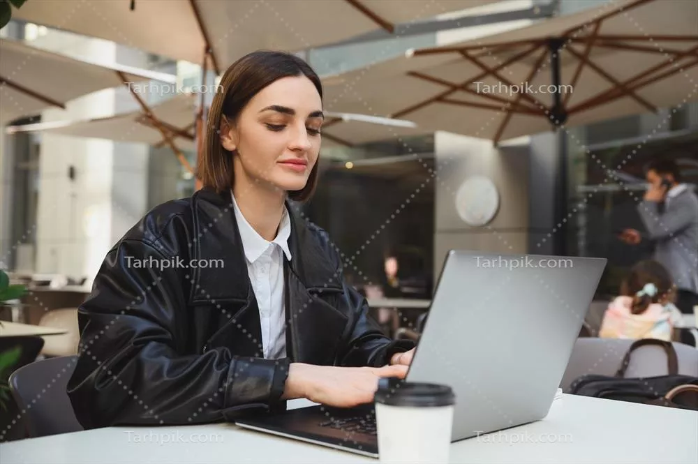 زن جوان با اعتماد به نفس: نویسنده، توسعه دهنده و خبرنگار دورکار در یک کافه تابستانی زیبا