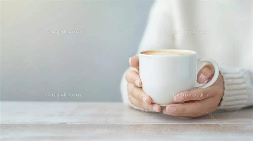 صبح زمستانی دنج با دست‌های holding فنجان قهوه گرم در یک صحنه مینیمالیستی هیوگه