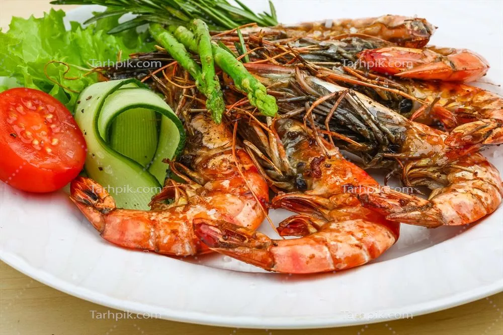 میگوهای کبابی بر روی بشقاب و پس زمینه چوبی: یک تجربه لذیذ